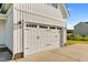 White two-car garage door with black hardware on a white farmhouse-style home at 105 Blooms Way, Kenly, NC 27542
