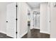 Hallway with hardwood floors, white doors, and neutral paint leading to bedroom and bathroom at 105 Blooms Way, Kenly, NC 27542