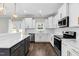 Open kitchen with white cabinets, granite countertops, stainless steel appliances, and a view to the backyard at 105 Blooms Way, Kenly, NC 27542