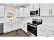 Modern kitchen with white cabinets, stainless steel appliances, and stylish herringbone backsplash at 105 Blooms Way, Kenly, NC 27542