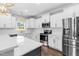Bright kitchen features white cabinetry, stainless steel appliances, granite countertops, and hardwood flooring at 105 Blooms Way, Kenly, NC 27542