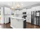 Stylish kitchen featuring white cabinets, stainless steel appliances, a center island, and modern lighting at 105 Blooms Way, Kenly, NC 27542