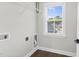 Bright laundry room features a window, white wire shelving, and hookups for a washer and dryer at 105 Blooms Way, Kenly, NC 27542