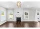 Bright living room boasts hardwood floors, fireplace with blue tile accents, and three windows at 105 Blooms Way, Kenly, NC 27542