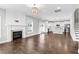 Open-concept living room with fireplace, hardwood floors, and seamless flow to the modern kitchen at 105 Blooms Way, Kenly, NC 27542