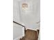 View of hardwood stairs with white risers, a wood railing and a modern light fixture overhead at 105 Blooms Way, Kenly, NC 27542