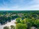 Expansive aerial view of a community with a lake, green spaces, and homes nestled among trees at 105 Ryder Cup Cir, Raleigh, NC 27603