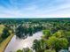 Stunning aerial view of a neighborhood with a lake surrounded by lush trees and manicured lawns at 105 Ryder Cup Cir, Raleigh, NC 27603