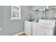 Bright laundry room with a washer, dryer, window and overhead shelving at 105 Ryder Cup Cir, Raleigh, NC 27603