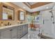 Bright bathroom features a double sink vanity, large window, and a glass enclosed shower at 1100 Queensbury Cir, Durham, NC 27713