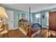 Charming bedroom with hardwood floors, blue walls, and a large four poster bed at 1100 Queensbury Cir, Durham, NC 27713
