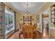 Formal dining room with a chandelier, wood table, and bright light from a window at 1100 Queensbury Cir, Durham, NC 27713