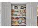 Organized pantry with shelving stocked with food items and small appliances at 1100 Queensbury Cir, Durham, NC 27713