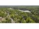 An aerial view of a residential neighborhood with mature trees and a large body of water at 117 Vicksburg Dr, Cary, NC 27513