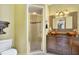 Well-lit bathroom featuring a glass shower, a decorative mirror, and double sinks with copper basins at 117 Vicksburg Dr, Cary, NC 27513