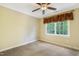 Bright bedroom with neutral carpet, yellow walls, a ceiling fan, and a large window at 117 Vicksburg Dr, Cary, NC 27513