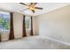 Neutral bedroom featuring a ceiling fan, large windows, and brown curtains at 117 Vicksburg Dr, Cary, NC 27513