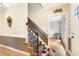 Inviting entryway featuring a staircase with decorative wrought iron details, hardwood flooring, and neutral wall colors at 117 Vicksburg Dr, Cary, NC 27513