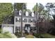 Charming two-story home with a light gray exterior, blue door, dormer windows, and lush landscaping at 117 Vicksburg Dr, Cary, NC 27513