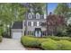Charming two-story home with a light gray exterior, blue door, dormer windows, and lush landscaping at 117 Vicksburg Dr, Cary, NC 27513