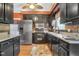 Kitchen with stainless steel appliances, dark cabinets, warm colored walls and countertops at 117 Vicksburg Dr, Cary, NC 27513
