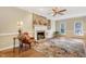 Bright living room with hardwood floors, a stone fireplace, ceiling fan, and a patterned area rug at 117 Vicksburg Dr, Cary, NC 27513