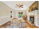 Bright living room with hardwood floors, a stone fireplace, ceiling fan, and glass doors leading to another room at 117 Vicksburg Dr, Cary, NC 27513