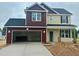 Two-story home with an attached two-car garage and neutral-toned siding, and a dark roof at 120 W Saltgrass Ln, Smithfield, NC 27577