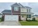 New two-story home featuring a two-car garage, red and beige siding, and a well-manicured front lawn at 120 W Saltgrass Ln, Smithfield, NC 27577