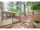 Serene backyard featuring a screened porch, stone steps, and lush landscaping at 1208 Lexington Farm Rd, Apex, NC 27502