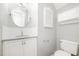 Well-lit half bath with granite countertop, round mirror, and white cabinetry at 1208 Lexington Farm Rd, Apex, NC 27502