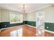 Elegant dining room with hardwood floors, wainscoting, and a chandelier fixture at 1208 Lexington Farm Rd, Apex, NC 27502