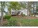Beautiful home exterior with lush landscaping, mature trees, and a well-maintained lawn at 1208 Lexington Farm Rd, Apex, NC 27502