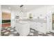 Bright kitchen featuring white cabinetry, a central island, and sleek tile flooring at 1208 Lexington Farm Rd, Apex, NC 27502
