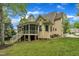 Back exterior featuring a screened-in porch, brick foundation, and stairs leading to the spacious backyard at 124 Mantle Dr, Clayton, NC 27527