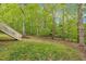 Exterior view of backyard featuring a deck with stairs and lush green trees in a serene natural setting at 124 Mantle Dr, Clayton, NC 27527