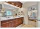 Bright bathroom with double sinks, decorative shelves, and a view to the bedroom at 124 Mantle Dr, Clayton, NC 27527