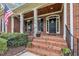 Inviting brick front porch with a welcome door and American flag at 124 Mantle Dr, Clayton, NC 27527