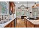 Open kitchen with wooden floors, granite countertops, stainless steel appliances, and plenty of natural light at 124 Mantle Dr, Clayton, NC 27527