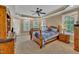 Large primary bedroom with a tray ceiling, a ceiling fan, carpet, and multiple windows allowing natural light at 124 Mantle Dr, Clayton, NC 27527