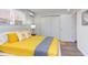 Bright bedroom with yellow bedding, sleek window blinds, and neutral gray flooring at 1309 Hudson Ave # D9, Durham, NC 27705