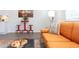 Cozy living room with an orange couch, modern decor, and an adjacent dining area at 1309 Hudson Ave # D9, Durham, NC 27705