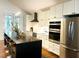 Stylish kitchen featuring stainless steel appliances, white cabinets, and a large kitchen island at 1310 Pender St, Raleigh, NC 27610