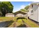 Backyard showcasing an metal carport with mature trees and a grassy area at 1329 Mebane St, Burlington, NC 27217