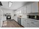 Well-lit white kitchen featuring stainless steel appliances, ample counter space, and hardwood floors at 1329 Mebane St, Burlington, NC 27217