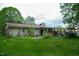 View of backyard showing the home's exterior, patio area, and a covered structure attached to the house at 133 Montree Ln, Graham, NC 27253