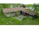 An aerial view of the backyard showing a patio, carport, green grass, and mature trees at 133 Montree Ln, Graham, NC 27253