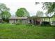 Backyard view featuring a carport, patio, and green grass at 133 Montree Ln, Graham, NC 27253