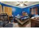 Blue-walled bedroom showcasing hardwood floors, a ceiling fan, and natural light at 133 Montree Ln, Graham, NC 27253