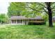 Charming single-story home with a cozy front porch and a large tree in the front yard at 133 Montree Ln, Graham, NC 27253